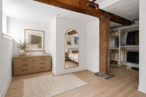 A room with a wooden floor and a large mirror on the wall.