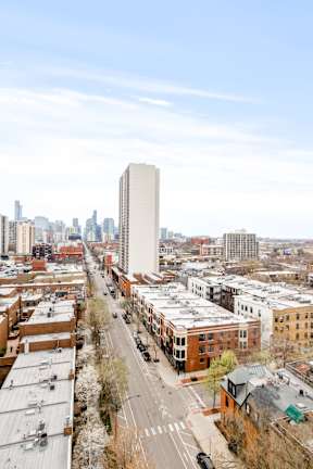 A cityscape with a tall building in the middle of the frame.