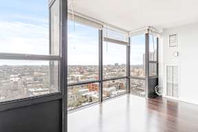 A large, empty room with a view of the cityscape outside.