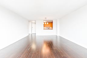 A long hallway with a wooden floor and white walls.
