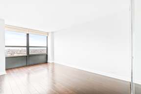 A room with a large window and wooden flooring.