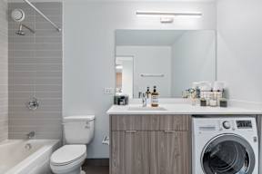 a bathroom with a toilet sink and a washing machine