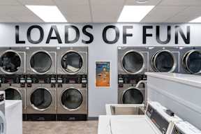 a row of washing machines in a laundromat with the doors of fun on