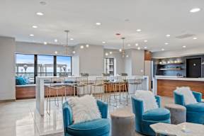 a lobby with blue chairs and tables and a bar
