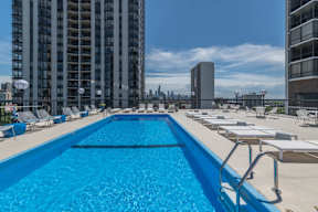 a swimming pool on the rooftop of a building with a city in the background