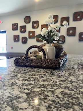 A wicker basket with a vase of flowers and eggs inside.