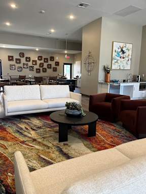 A living room with a white couch, a coffee table, and a rug.