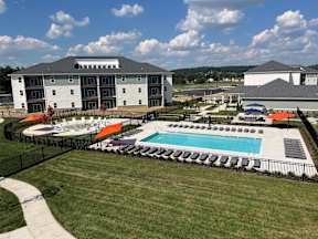 A large building with a pool in front of it.