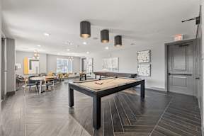 A pool table is in the middle of a room with a wooden floor at The Preserve at Preston Trails Apartments, Cedar Hill, Texas
