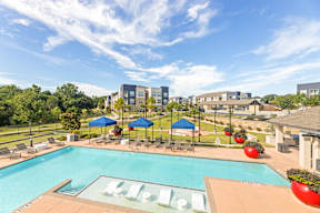 A pool with a slide and a building in the background at The Preserve at Preston Trails Apartments, Cedar Hill, TX, 75104