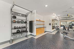 A gym with a weight rack and exercise equipment at The Preserve at Preston Trails Apartments, Cedar Hill, Texas