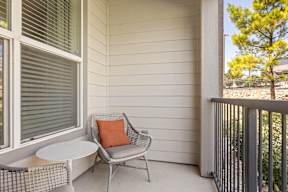A patio with a chair and a table at The Preserve at Preston Trails Apartments, Cedar Hill, TX