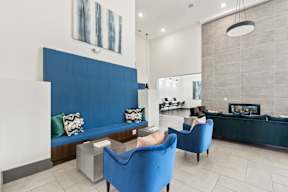 A blue sofa and chair in a room with a fireplace at The Preserve at Preston Trails Apartments, Cedar Hill 75104