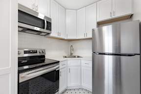 A kitchen with a stove, oven, microwave, and refrigerator.