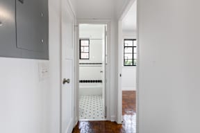 A white hallway with a doorway leading to a bathroom  at Marleigh apartments located in Indianapolis, IN