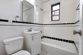 A white bathroom with a tub, toilet, and sink.