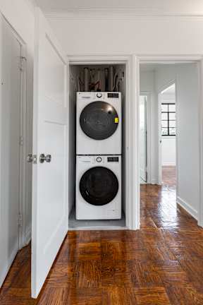 A white washer and dryer in a small room.