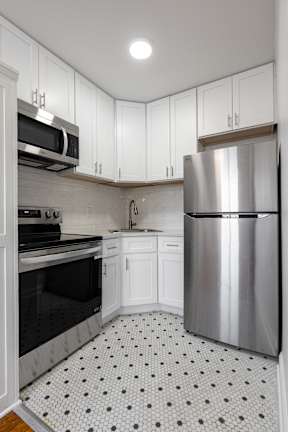 A kitchen with a refrigerator, microwave, oven, and sink  at Marleigh apartments located in Indianapolis, IN