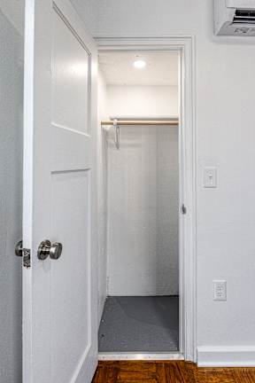 A white door with a silver handle and a small hallway.