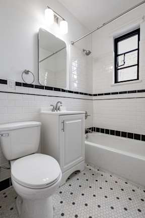A white toilet sits next to a white sink in a bathroom.