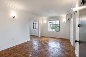 A room with wooden flooring and white walls.