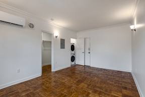 A room with wooden flooring and white walls.