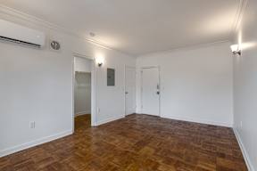 A room with wooden flooring and white walls.