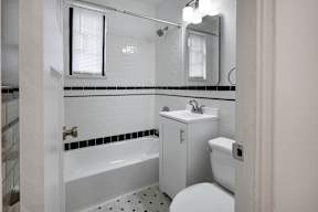 A white toilet sits next to a sink in a small bathroom  at Marleigh apartments located in Indianapolis, IN