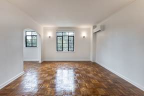 A room with wooden floors and two windows.