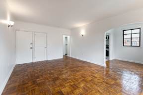 A room with wooden flooring and white walls.
