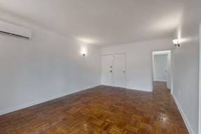 A room with wooden flooring and white walls.