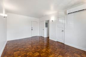 Large bedroom with wooden flooring and white walls  at Marleigh apartments located in Indianapolis, IN