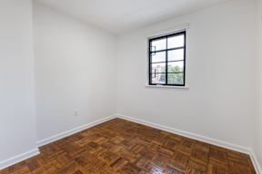 A room with a window and wooden flooring.