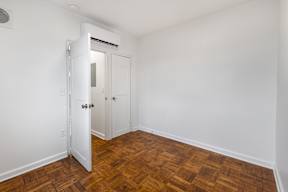 A room with a wooden floor and a white door.
