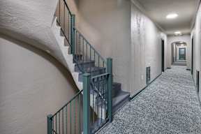A staircase with a green railing at Marleigh apartments located in Indianapolis, IN