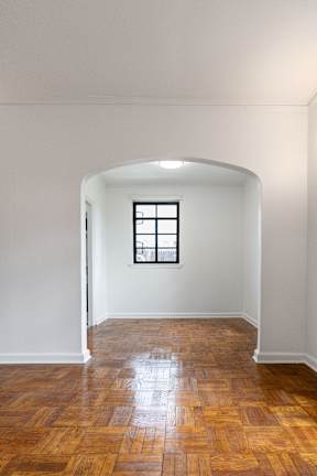 A room with a window and wooden floors.