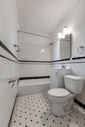 A white toilet with a black and white floor.