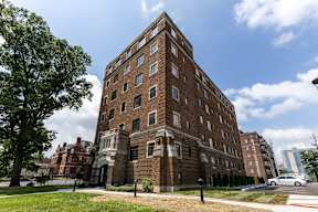 A large red brick building with a tree in front of it  at Marleigh apartments located in Indianapolis, IN