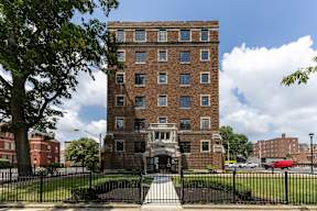 A large brick apartment building with a black fence in front  at Marleigh apartments located in Indianapolis, IN