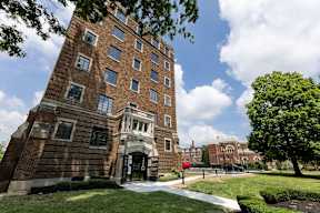 A tall brick apartment building with a crown molding, historic architecture, green lawn in front  at Marleigh apartments located in Indianapolis, IN