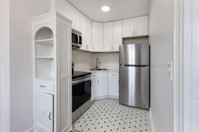Renovated kitchen with white cabinets and a silver refrigerator and stainless steal appliances  at Marleigh apartments located in Indianapolis, IN