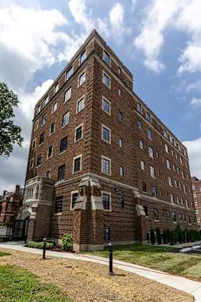 A tall brick apartment building with many windows and natural lighting at Marleigh apartments located in Indianapolis, IN