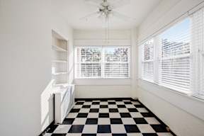 A black and white checkered floor in a room with a ceiling fan.