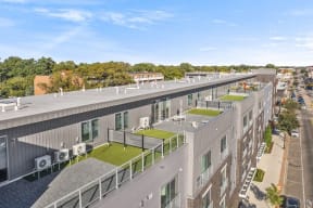 an aerial view of a large building with a roof terrace and green grass