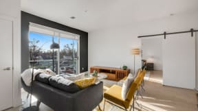 a living room with a couch and chairs and a large window