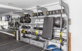 a gym with weights and cardio equipment on a rack