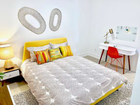 a bedroom with a bed and a desk with a chair