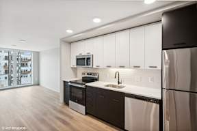 Harbourline Apartments, St Paul a kitchen with white cabinets and stainless steel appliances and a refrigerator