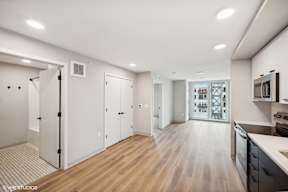 Harbourline Apartments, St Paul a renovated living room and kitchen with white walls and wood floors