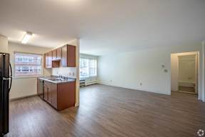 A kitchen with brown cabinets and a black refrigerator.